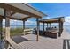 Lake house dock with a boat lift, boat and covered seating area overlooking the serene lake at 38314 Echols Rd, Leesburg, FL 34788