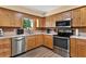 Bright kitchen featuring stainless steel appliances, wooden cabinets, and a window overlooking the water at 38314 Echols Rd, Leesburg, FL 34788