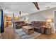 Living room features wood-look floors, leather seating, ceiling fans, and adjacent kitchen at 38314 Echols Rd, Leesburg, FL 34788