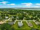 Aerial view showcasing a residential area, lush greenery, and a lake in the distance, highlighting the community setting at 39145 Treeline Dr, Lady Lake, FL 32159