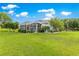 Expansive backyard featuring lush lawn, mature trees, and a screened lanai, perfect for outdoor enjoyment at 39145 Treeline Dr, Lady Lake, FL 32159