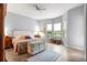 Bright bedroom with wood-look tile floors, ceiling fan, and trunk at the foot of the bed at 39145 Treeline Dr, Lady Lake, FL 32159