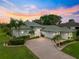 Beautiful single-story home featuring a brick driveway, manicured landscaping, and a two-car garage at 39145 Treeline Dr, Lady Lake, FL 32159