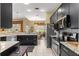 Modern kitchen with black cabinets, granite countertops, and stainless steel appliances at 39145 Treeline Dr, Lady Lake, FL 32159
