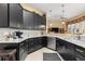 Stylish kitchen featuring granite countertops, dark cabinets, and stainless steel appliances at 39145 Treeline Dr, Lady Lake, FL 32159