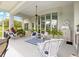A wide lanai features bright white patio, wicker furniture, and views of the green backyard at 39145 Treeline Dr, Lady Lake, FL 32159