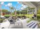 A screened lanai showcases outdoor seating, a dining table, and a soothing hot tub with views of the lush backyard at 39145 Treeline Dr, Lady Lake, FL 32159