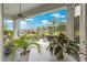 A glass-enclosed lanai featuring an array of potted plants, stylish outdoor seating, and a fan at 39145 Treeline Dr, Lady Lake, FL 32159