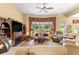 Cozy living room with tile floors, a fireplace, built-in entertainment, and large windows at 39145 Treeline Dr, Lady Lake, FL 32159