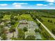 Aerial view of the community tennis courts, with lush green surroundings and nearby golf course at 39145 Treeline Dr, Lady Lake, FL 32159