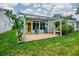 This is a backyard with a patio, two blue chairs, green grass, and a cactus at 409 Westwood Dr, Leesburg, FL 34748