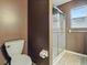 This is a bathroom with a toilet, shower, and window with natural light at 409 Westwood Dr, Leesburg, FL 34748