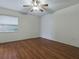 This bedroom features wood floors, a ceiling fan, and a window at 409 Westwood Dr, Leesburg, FL 34748