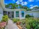 Close-up shot of a well-maintained walkway to a lovely screened in porch surrounded by beautiful landscaping at 409 Westwood Dr, Leesburg, FL 34748