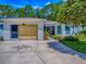 Home with a well-maintained lawn featuring a decorative driveway, attached garage, and lovely flower beds at 409 Westwood Dr, Leesburg, FL 34748