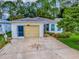 Charming single-story home with a well-manicured lawn, garage, and decorative driveway at 409 Westwood Dr, Leesburg, FL 34748