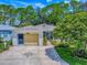 Home with a well-maintained lawn featuring a decorative driveway, attached garage, and lovely flower beds at 409 Westwood Dr, Leesburg, FL 34748