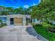Charming home featuring a decorative driveway, attached garage, and manicured lawn with lovely flower beds at 409 Westwood Dr, Leesburg, FL 34748