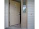 Beige front door with sidelight and vinyl siding adds curb appeal to this home at 409 Westwood Dr, Leesburg, FL 34748