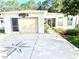 Charming home featuring a one-car garage and a unique compass design in the driveway at 409 Westwood Dr, Leesburg, FL 34748