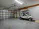 This is a garage with a golf cart, metal garage door, and storage at 409 Westwood Dr, Leesburg, FL 34748