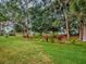Beautifully maintained lawn with mature trees and lush landscaping at 409 Westwood Dr, Leesburg, FL 34748