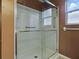 This bathroom features a walk-in shower with sliding glass doors at 409 Westwood Dr, Leesburg, FL 34748