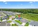 An aerial view showcases the home in a community setting, surrounded by trees and other properties at 4157 Tiedemann Loop, The Villages, FL 32163