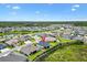 Aerial view shows the home's location in a neighborhood with a pond and multiple homes at 4157 Tiedemann Loop, The Villages, FL 32163