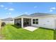 Well-maintained backyard featuring a covered patio and lush green lawn at 4157 Tiedemann Loop, The Villages, FL 32163