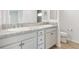 Bathroom with dual vanities, granite counters, and white cabinetry at 4157 Tiedemann Loop, The Villages, FL 32163