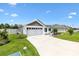 Inviting home exterior with a green lawn, complemented by a concrete driveway and a gray two-car garage at 4157 Tiedemann Loop, The Villages, FL 32163