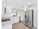 Modern kitchen with stainless steel appliances, white cabinets, and hardwood style flooring at 4157 Tiedemann Loop, The Villages, FL 32163