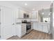 Bright kitchen featuring stainless appliances, white cabinetry, and hardwood style floors at 4157 Tiedemann Loop, The Villages, FL 32163