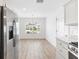 Eat-in kitchen featuring stainless appliances, white cabinetry, and hardwood style flooring at 4157 Tiedemann Loop, The Villages, FL 32163