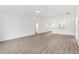 Minimalist living room featuring light wood flooring, connecting seamlessly to the kitchen, creating an open and airy space at 4157 Tiedemann Loop, The Villages, FL 32163