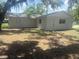 Home's exterior is complemented by a spacious backyard with grass and trees, a canvas for outdoor customization at 460 Wisteria Ave, Umatilla, FL 32784