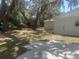 A sprawling backyard featuring mature trees, a concrete patio and potential for outdoor living at 460 Wisteria Ave, Umatilla, FL 32784