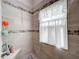 Modern bathroom with stylish tile shower, mosaic accents, and large window for natural light at 4800 Tara View Rd, Leesburg, FL 34748