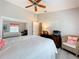 Bedroom featuring a mirrored closet, desk space, chair and ceiling fan at 4800 Tara View Rd, Leesburg, FL 34748