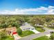 Aerial view of the well-maintained single-story home with a blue sky, green lawn, and mature trees at 4800 Tara View Rd, Leesburg, FL 34748