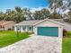 Inviting one-story home with a lovely front yard, complemented by a teal garage door and matching shutters at 4800 Tara View Rd, Leesburg, FL 34748