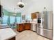 Well-lit kitchen with stainless steel appliances, wood cabinets, and an adjacent dining area at 4800 Tara View Rd, Leesburg, FL 34748