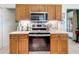 Kitchen featuring stainless steel appliances, wood cabinets, and stylish backsplash at 4800 Tara View Rd, Leesburg, FL 34748
