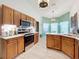 Charming kitchen with wood cabinets, stainless steel appliances, and a bright breakfast nook with a bay window at 4800 Tara View Rd, Leesburg, FL 34748