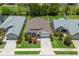 Aerial view of a well-maintained single Gathering home with manicured lawns, mature trees, and gray roof at 5019 Ne 125Th Loop, Oxford, FL 34484