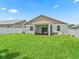 Home's rear exterior showing lawn, privacy fence and screened patio at 5019 Ne 125Th Loop, Oxford, FL 34484
