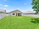 Home's rear exterior showing lawn, privacy fence and screened patio at 5019 Ne 125Th Loop, Oxford, FL 34484