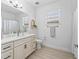 Bathroom with neutral colors, sleek vanity with modern fixtures, and a large well-lit mirror at 5019 Ne 125Th Loop, Oxford, FL 34484