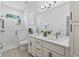 Bright bathroom featuring dual sinks, modern fixtures, and a walk-in shower with glass enclosure at 5019 Ne 125Th Loop, Oxford, FL 34484